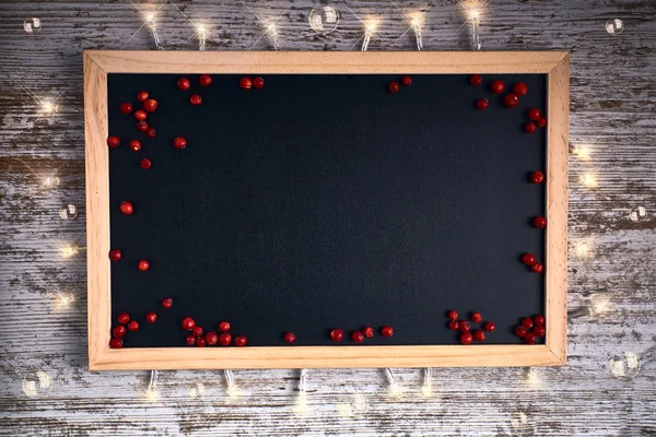 Чорний шифер з маленькими червоними ягодами і вогнями — стокове фото