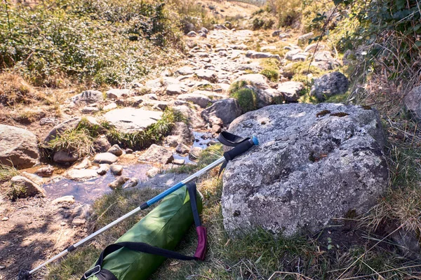 Bâton de randonnée et sac à dos sur un chemin de pierre au pied du m — Photo