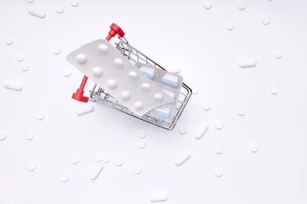 하얀 배경에 알약, 약, 약병들이 있는 쇼핑 카트. 약국 의약품. — 스톡 사진