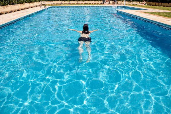 Mulher nadando em uma piscina — Fotografia de Stock