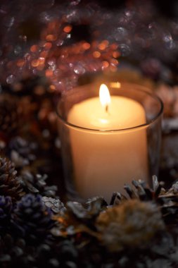 Advent dekorasyon, çelenk, mum. Karanlıkta bir mum güzel dekoratif çelenk içinde yanıyor.