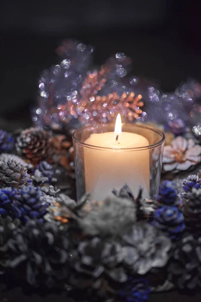 Advent dekorasyon, çelenk, mum. Karanlıkta bir mum güzel dekoratif çelenk içinde yanıyor.