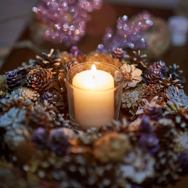 Advent dekorasyon, çelenk, mum. Karanlıkta bir mum güzel dekoratif çelenk içinde yanıyor.