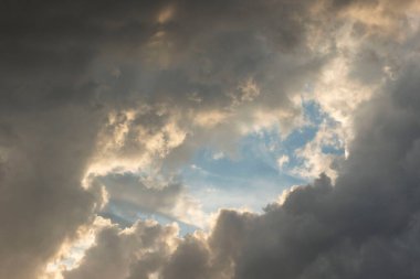 Güneş batarken ormanın üzerinde parlak sarı-turuncu renkler kümülüs koyu siyah renkli bulutlar..