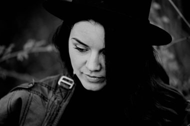 Portre, ormanda siyah şapkalı bir kız.