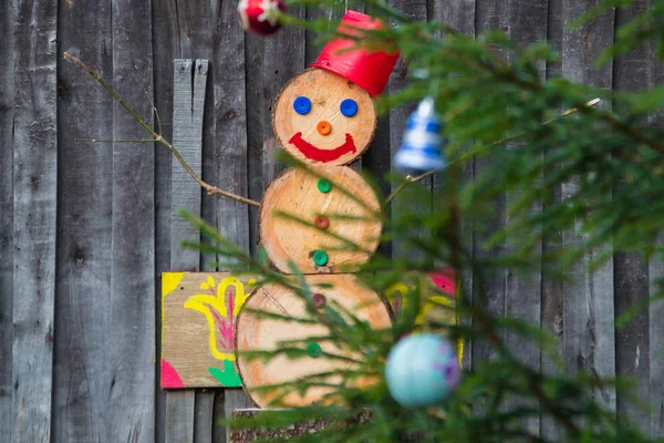 A snowman made of wood blocks to celebrate Christmas during a snowless winter