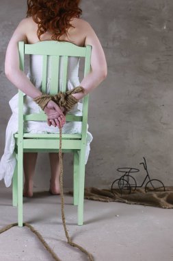 Genç kız yere bağlı. Kaçırılan kız. Kurban o