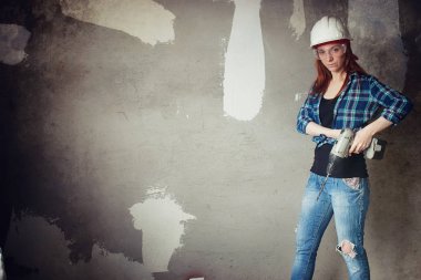 Kız dairede tamirat yapıyor. Eve yeni bir daireye taşınıyor. İşçi onarım, sıvalı yapar ve duvar matkaplar.