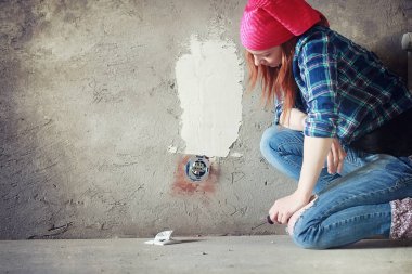Kız dairede tamirat yapıyor. Eve yeni bir daireye taşınıyor. İşçi onarım, sıvalı yapar ve duvar matkaplar.