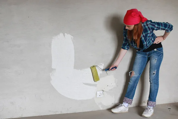Kız dairede tamirat yapıyor. Eve yeni bir daireye taşınıyor. İşçi onarım, sıvalı yapar ve duvar matkaplar. — Stok fotoğraf