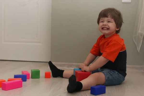 Young kid playing on a floor in a room — Stock Photo, Image