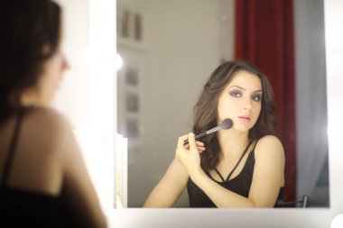 Güzel kız makyaj yapıyor.