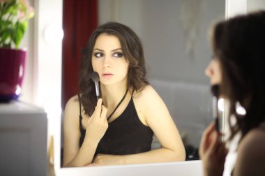 Güzel kız makyaj yapıyor.