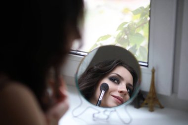 Güzel kız makyaj yapıyor.