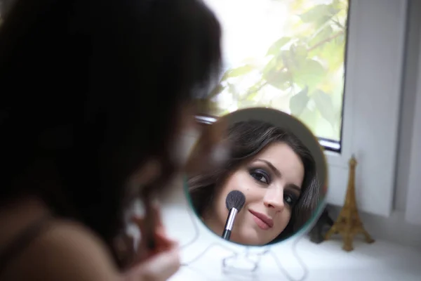 Красивая девушка делает косметику — стоковое фото