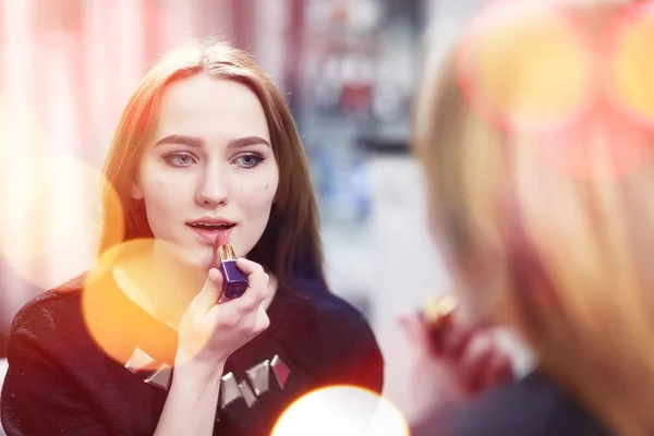 A young girl does make-up in a beauty salon. The girl in front o — Stock Photo, Image