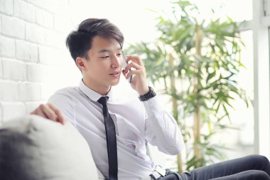 Genç Asyalı işadamı bir kafede bir ortak için bekliyor. Bu