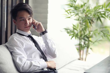 Genç Asyalı işadamı bir kafede bir ortak için bekliyor. Bu