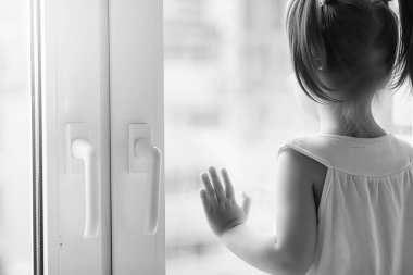 Küçük bir kız kenarında oturuyor. Bir buket çiçek