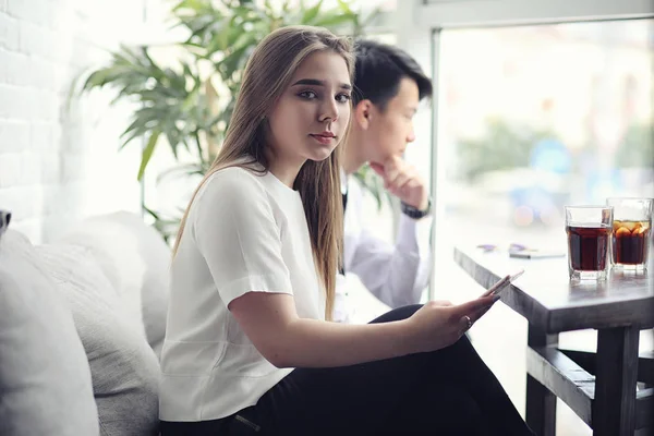 Een jonge Aziatische zakenman wacht een partner in een café. Bu — Stockfoto