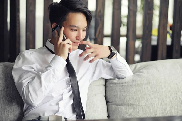 Genç Asyalı işadamı bir kafede bir ortak için bekliyor. Bu