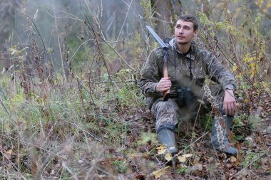 Kamuflaj ve bahar hun üzerinde orman Kuşağı'nda silahlı adam