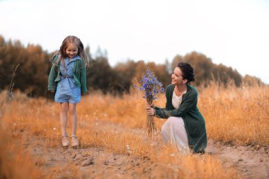 Anne ve kızı yolda yürüyor.