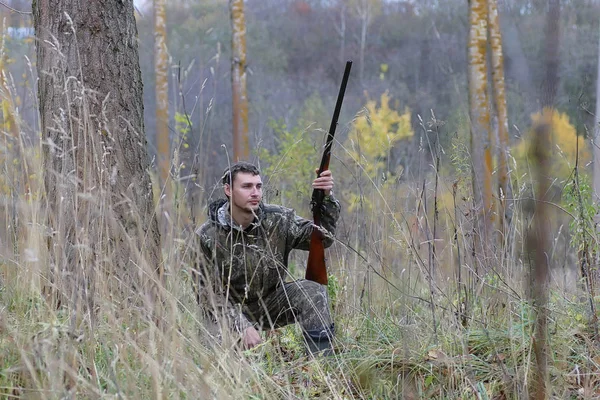 Muž v maskování a se zbraněmi v lesní pás na jaře hun — Stock fotografie