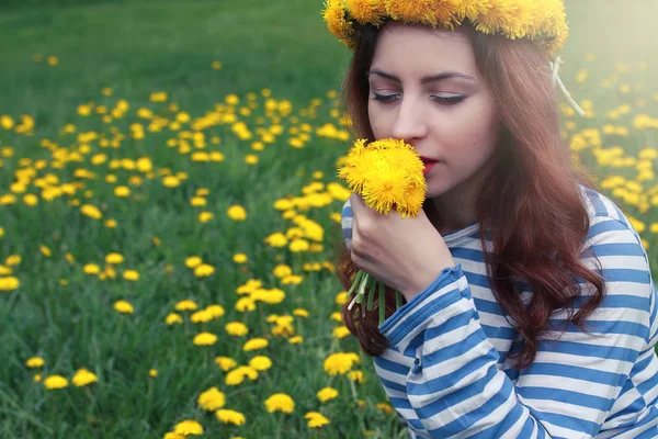 Gadis beristirahat pada hari yang cerah di padang rumput dari dandelion kuning — Stok Foto