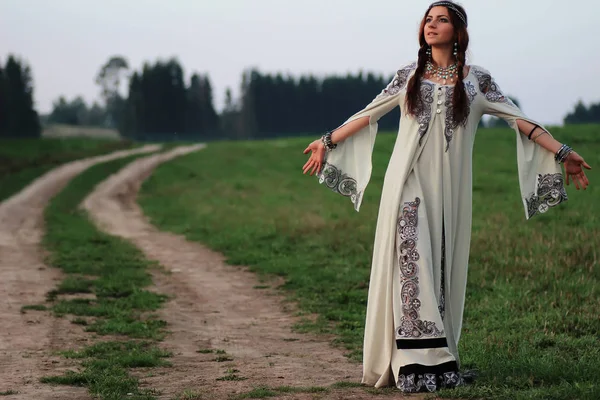 Flicka i lång klänning road land — Stockfoto