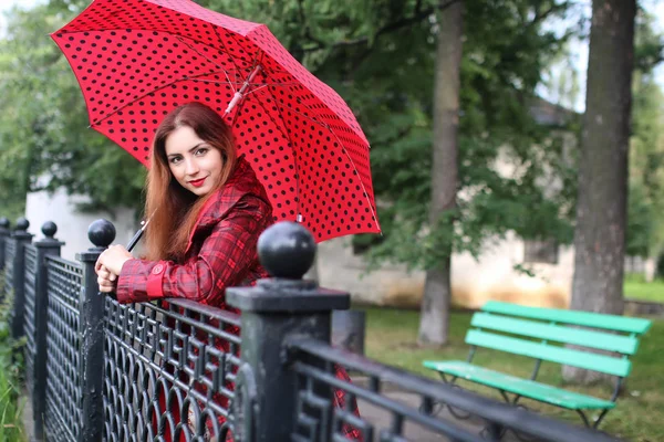 Γυναίκα με ομπρέλα κόκκινα στο δέντρο του δρόμου — Φωτογραφία Αρχείου