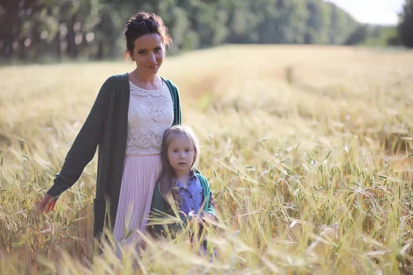 Una joven madre camina en los campos de trigo —  Fotos de Stock