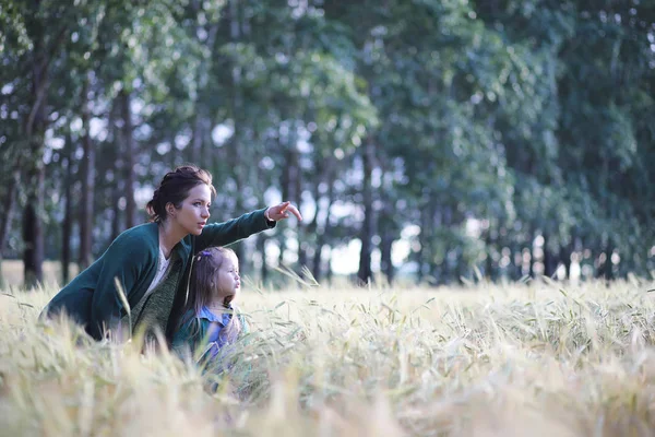 Молодая мать ходит по пшеничным полям — стоковое фото