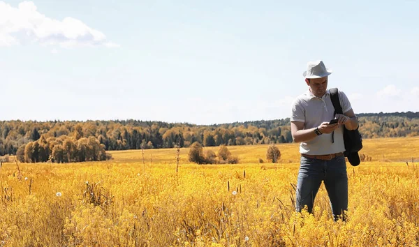 A young man is traveling in nature. Traveling with a backpack on — Stock Photo, Image