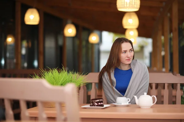 Junges Mädchen sitzt im Café und trinkt Tee — Stockfoto