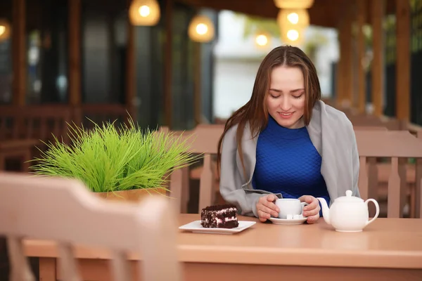 Junges Mädchen sitzt im Café und trinkt Tee — Stockfoto