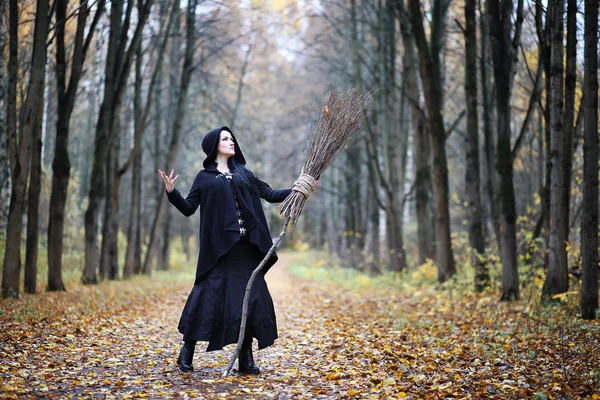 Una donna in abito da strega in una foresta — Foto Stock