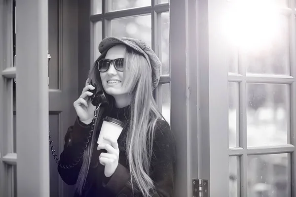 Hermosa jovencita en una cabina telefónica. La chica está hablando en th — Foto de Stock