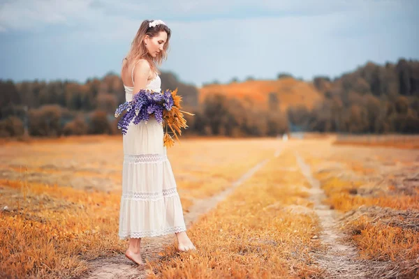 Mädchen mit einem Blumenstrauß im Herbst — Stockfoto