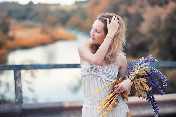 Meisje met een boeket van bloemen in de herfst — Stockfoto