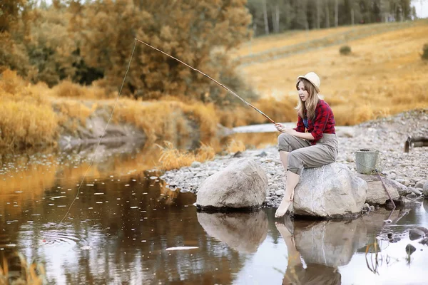 Ragazza in autunno con una canna da pesca — Foto Stock