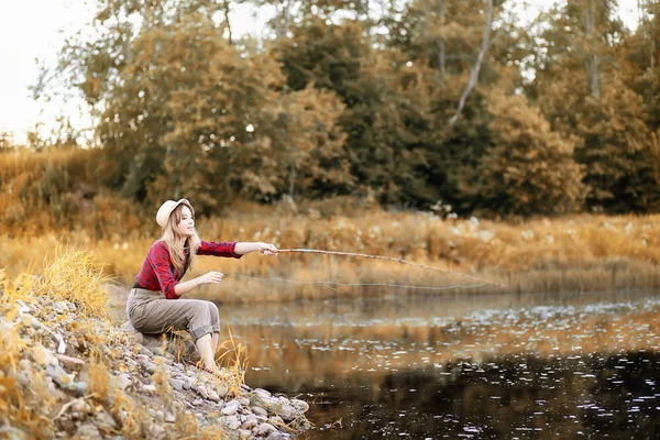 Fille en automne avec une canne à pêche — Photo