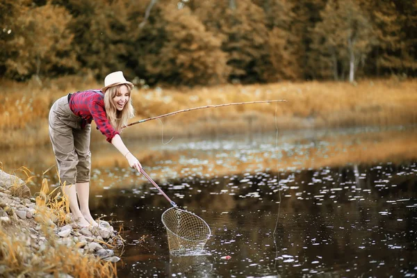 Flicka i höst med ett fiskespö — Stockfoto