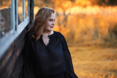 Sonbahar parkında yetişkin bir kadın.