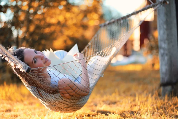 Mooi meisje in hangmat lezen van een boek — Stockfoto