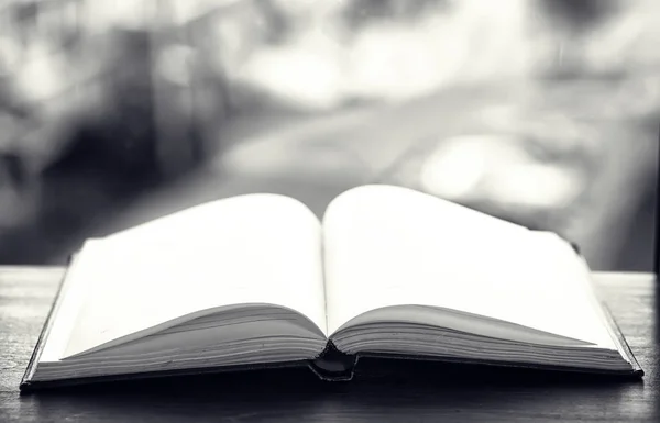 Aufgeschlagenes Buch und ein Tisch schwarz-weiß — Stockfoto