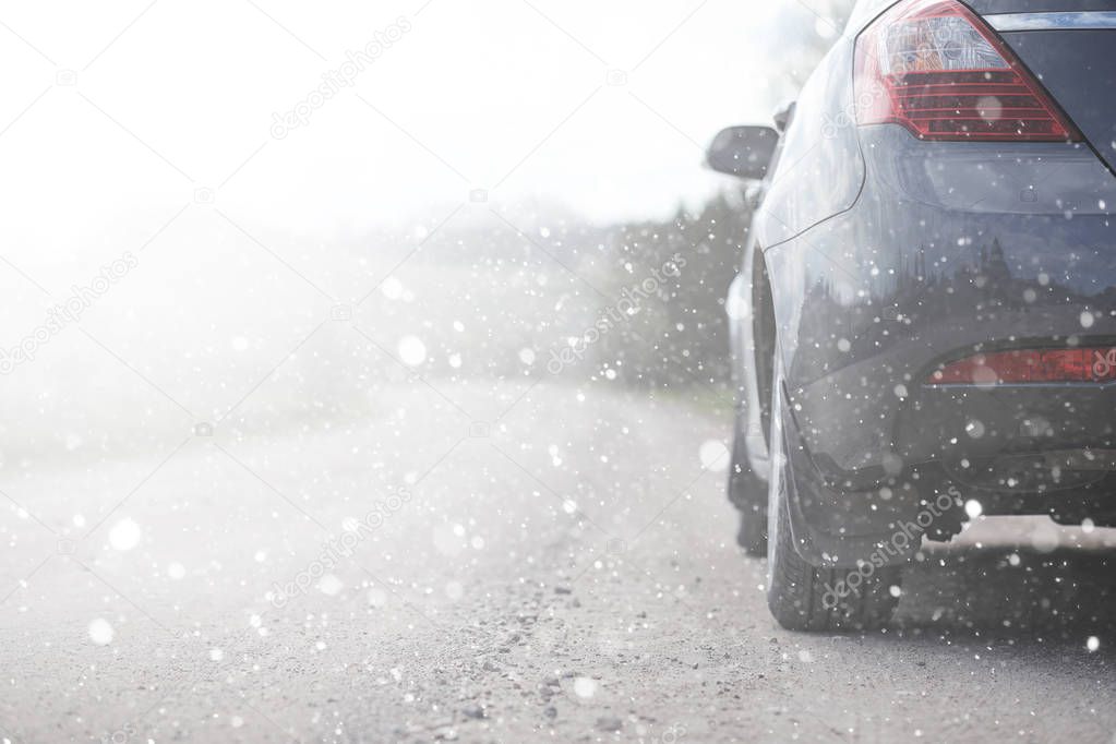 A car on a rural road in the first autumn snow. The first winter