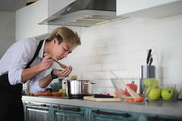 Cozinha asiática prepara comida em um terno de cozinheiro — Fotografia de Stock