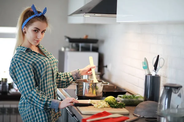 Uma menina bonita na cozinha prepara comida — Fotografia de Stock