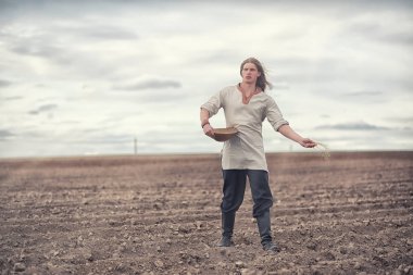 Genç bir köylü tahıl alanıyla sows